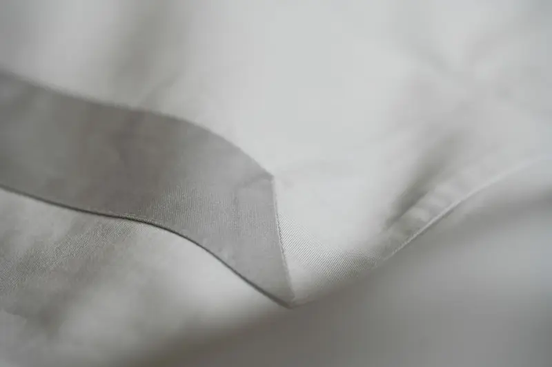 Detalj šava i sive trake na jastučnici posteljine IL Design